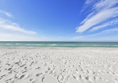 Image of a beach with footprints in the sand.